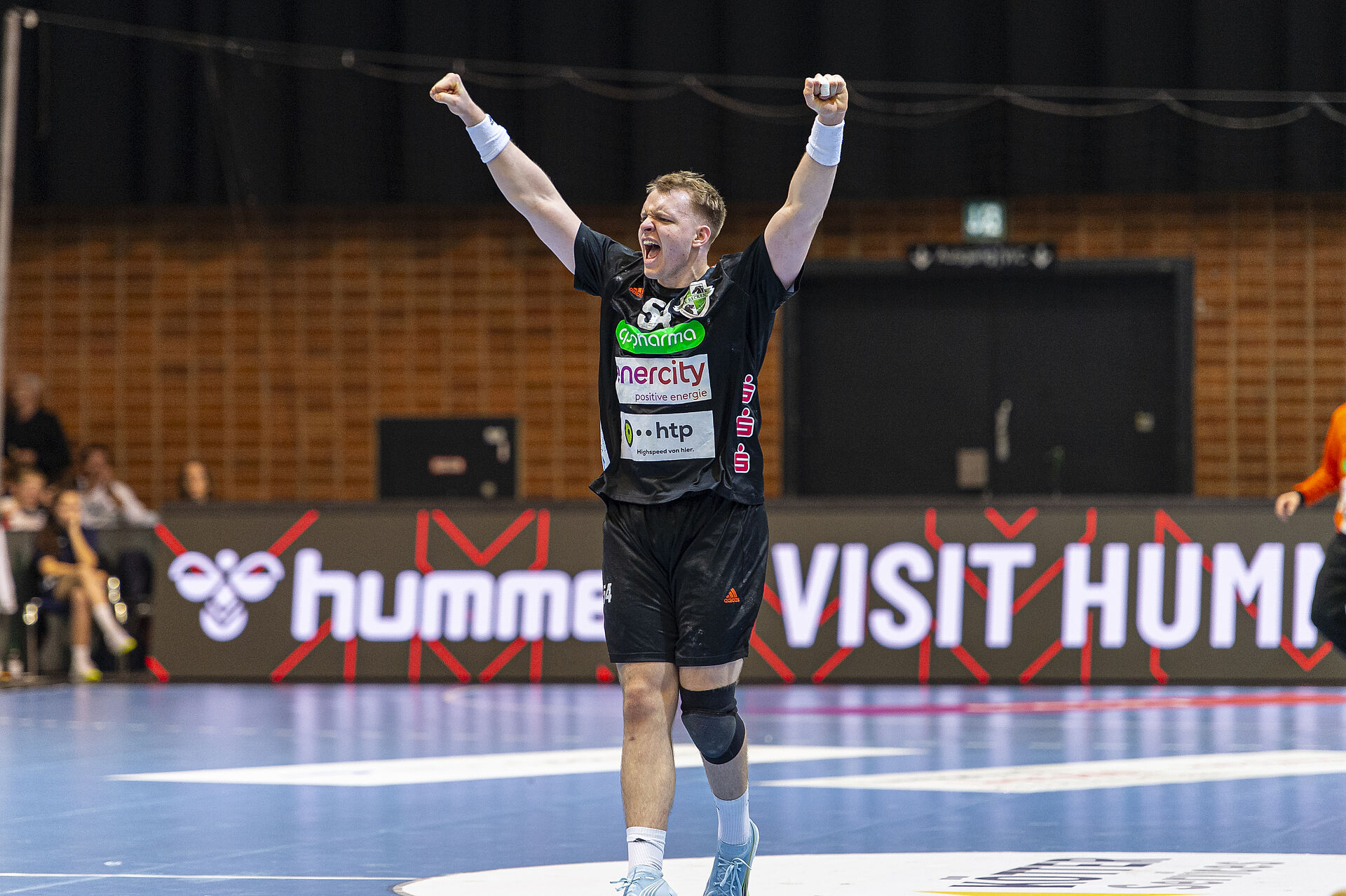 Ein Handballer der Recken reißt vor Freude die Hände in die Luft beim Spiel gegen Athen.